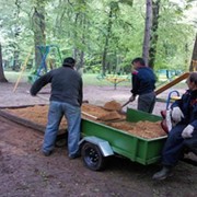 25.05.2015  Рабочие наполняют песочницу в детском городке парка культуры новым песком.